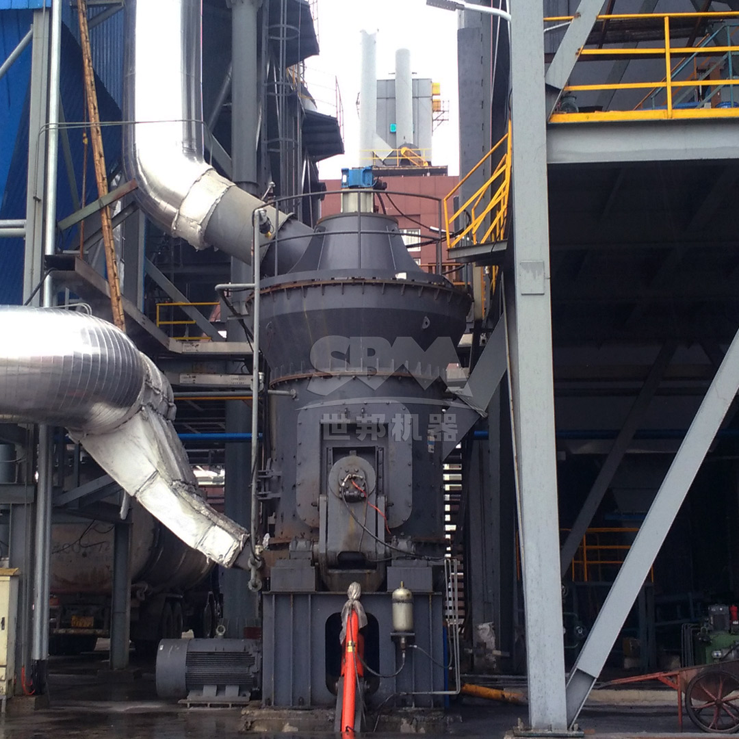 A large vertical roller mill during installation in an industrial plant, showing its substantial size and integrated structure.