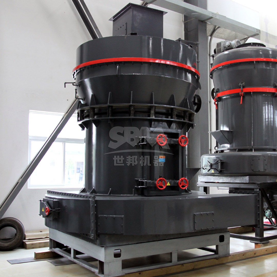 Industrial grinding mill in operation within a mineral processing plant, showing material feed and dust collection connections.